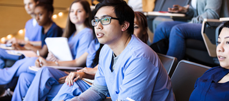 Why Community Colleges Can Be a Powerful Resource to Strengthen the Clinical Workforce Pipeline. A diverse group of clinicians in a classroom raptly pay attention to a presentation.